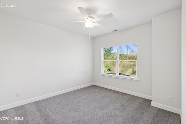 unfurnished room with ceiling fan and carpet