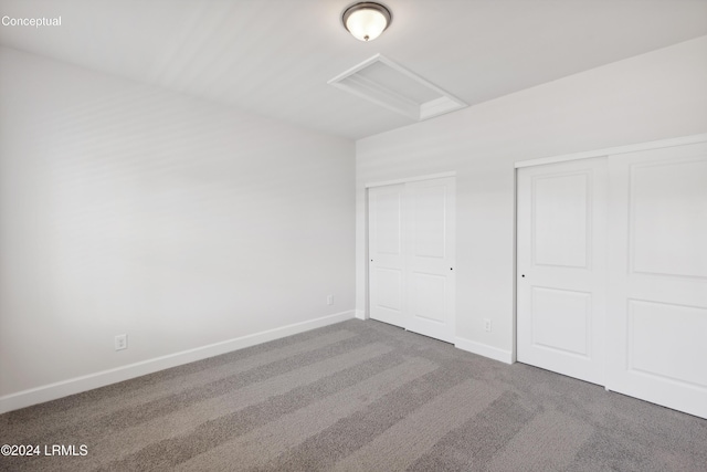 unfurnished bedroom with multiple closets and carpet floors