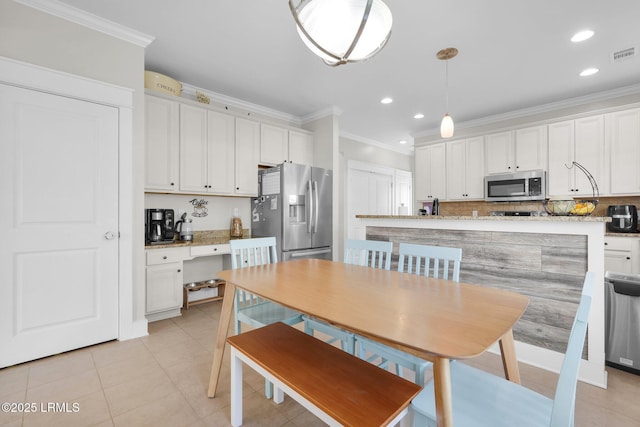 kitchen with backsplash, ornamental molding, appliances with stainless steel finishes, hanging light fixtures, and white cabinets