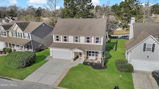 traditional-style home with a front lawn, an attached garage, and driveway