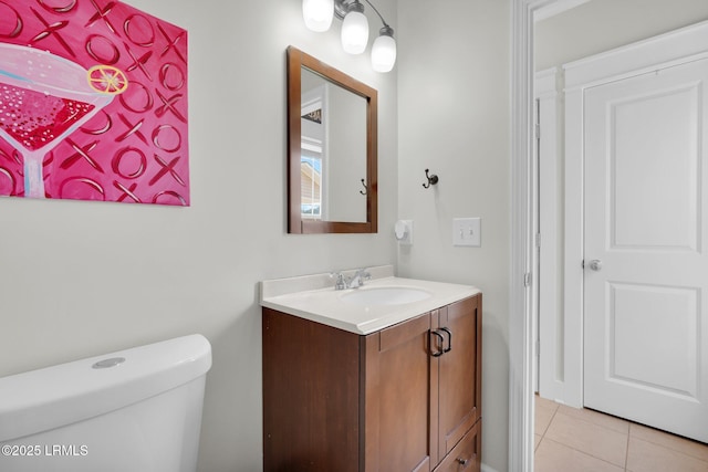 half bath featuring tile patterned floors, toilet, and vanity