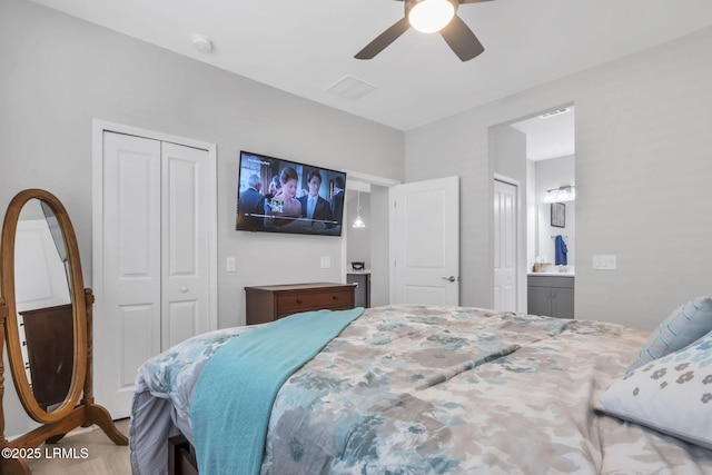 bedroom with ceiling fan, ensuite bath, and a closet