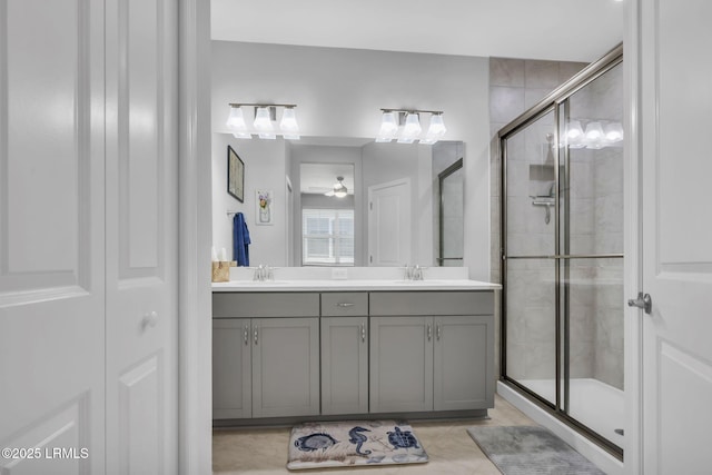 bathroom featuring vanity, a shower with shower door, and ceiling fan