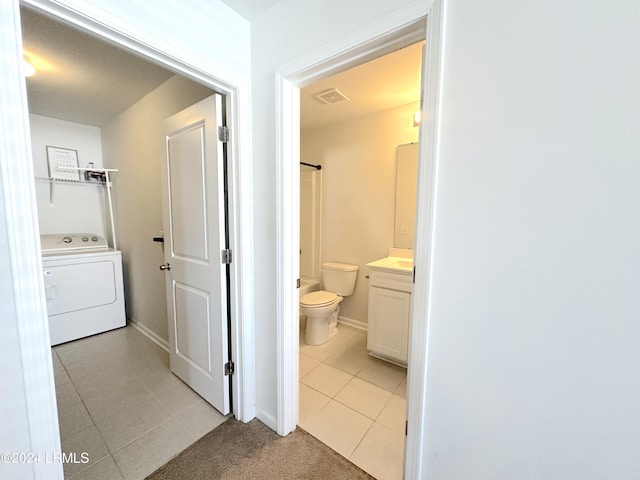 bathroom with vanity, toilet, washer / dryer, and tile patterned flooring