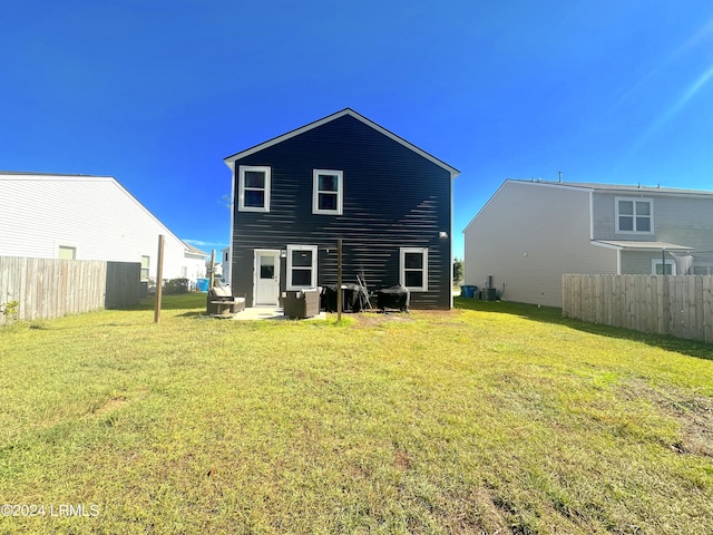 rear view of property featuring a lawn