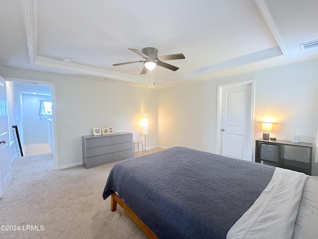 bedroom featuring light carpet, a tray ceiling, ornamental molding, and ceiling fan