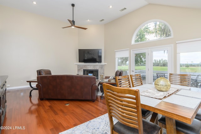 dining space featuring wood-type flooring, high vaulted ceiling, and ceiling fan