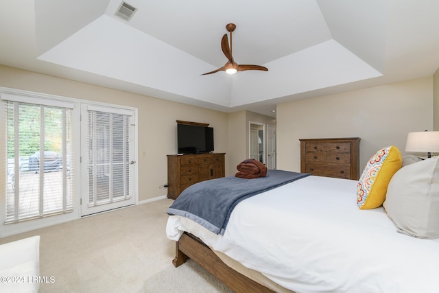 bedroom with a tray ceiling, ceiling fan, and carpet flooring