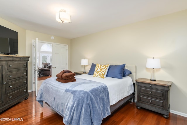 bedroom with dark hardwood / wood-style flooring and a closet