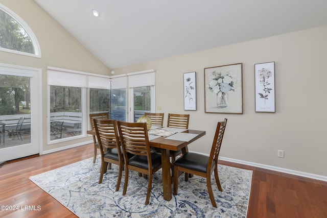 dining room featuring high vaulted ceiling and hardwood / wood-style floors