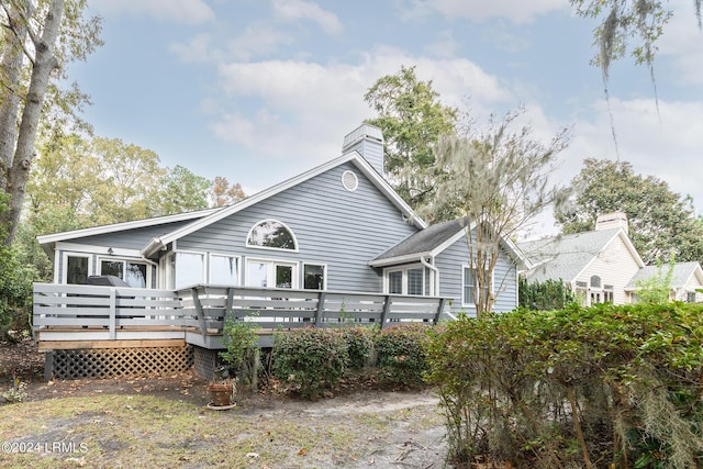 rear view of property featuring a wooden deck