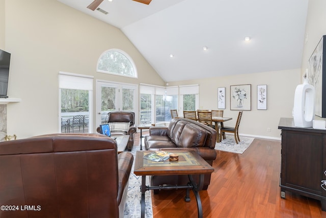 living room with ceiling fan, dark hardwood / wood-style floors, a wealth of natural light, and high vaulted ceiling