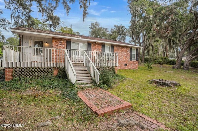 ranch-style home featuring a deck and a front yard