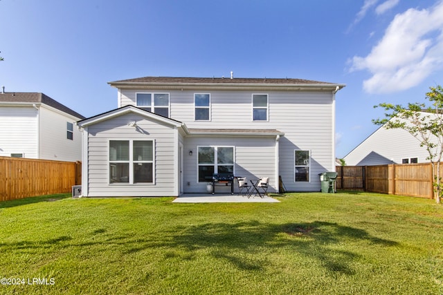 rear view of property featuring a yard and a patio area