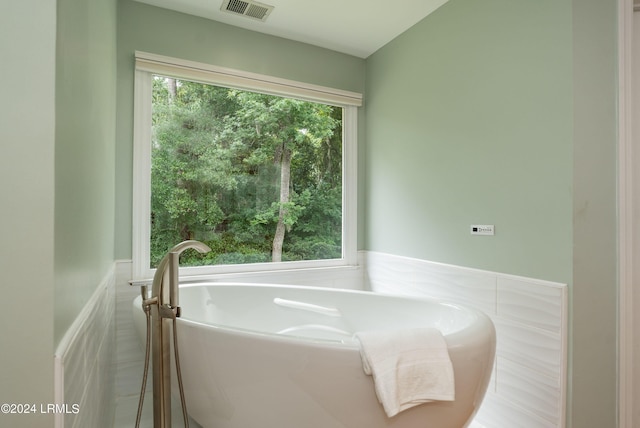 bathroom featuring a bath and a wealth of natural light