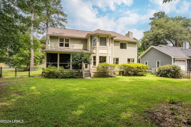 back of property featuring a yard and a sunroom