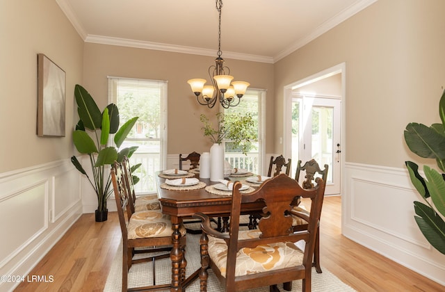 dining area with crown molding, light hardwood / wood-style floors, and a chandelier