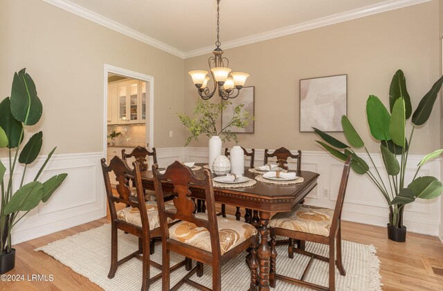 dining room featuring ornamental molding, a chandelier, and light wood-type flooring