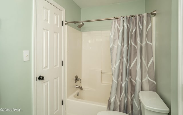 bathroom featuring shower / bathtub combination with curtain and toilet