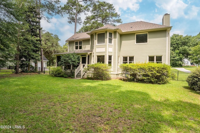 rear view of property featuring a yard