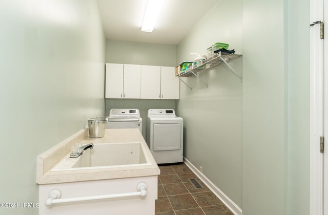 laundry area with sink, washer and clothes dryer, and cabinets