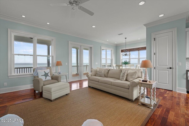 living area with baseboards, ornamental molding, wood finished floors, and french doors