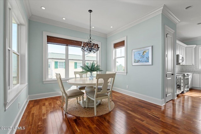 dining area with dark wood-style floors, crown molding, baseboards, and an inviting chandelier