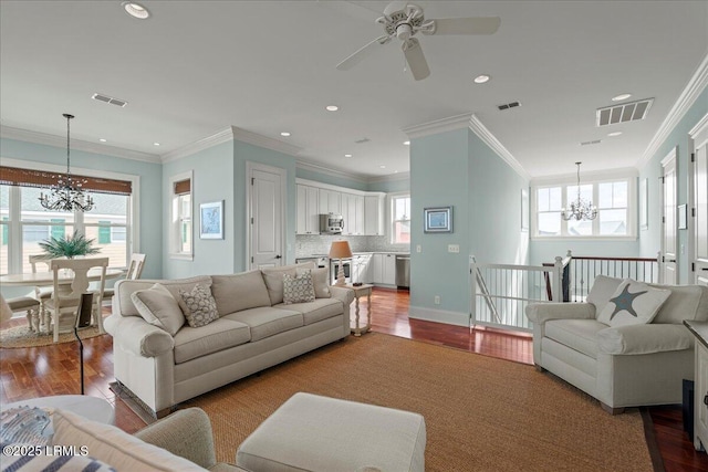 living room with wood finished floors, visible vents, and a healthy amount of sunlight