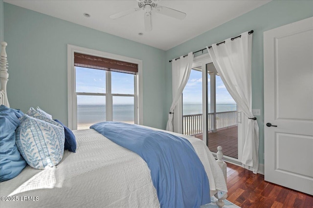 bedroom featuring access to outside, a water view, wood finished floors, and a ceiling fan