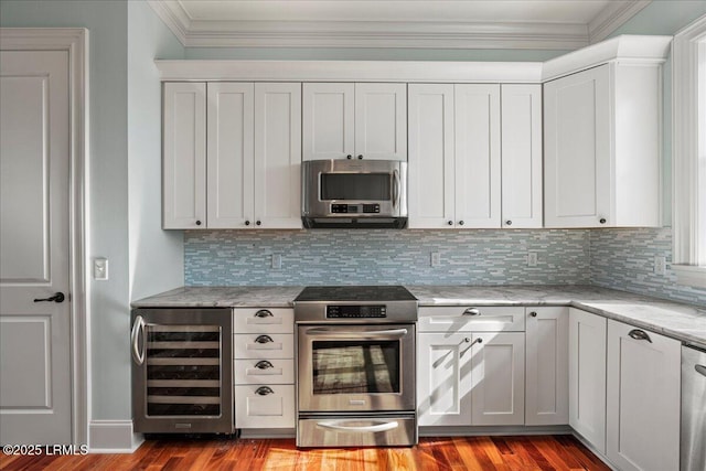 kitchen featuring wine cooler, appliances with stainless steel finishes, crown molding, and wood finished floors