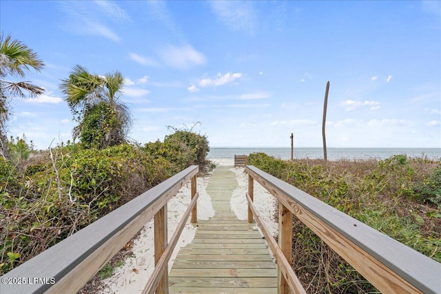 view of community with a water view and a beach view