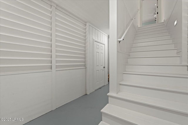 staircase featuring finished concrete flooring