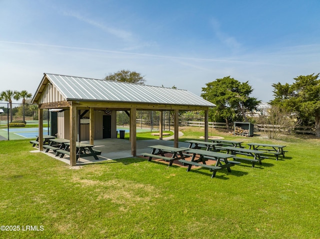 view of property's community with a yard, fence, and an outdoor structure