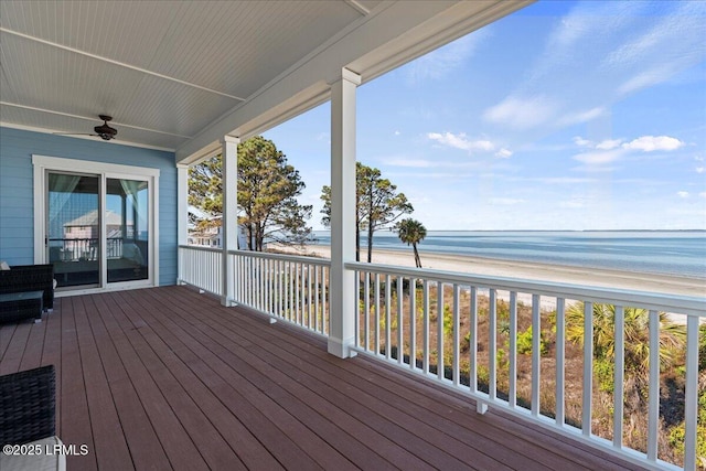 wooden deck with a view of the beach, a water view, and ceiling fan