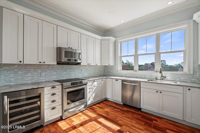 kitchen with appliances with stainless steel finishes, wine cooler, a wealth of natural light, and a sink