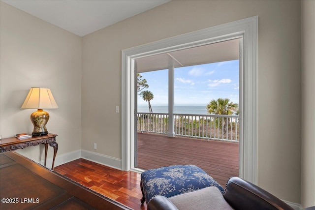 doorway featuring a water view, parquet floors, and baseboards