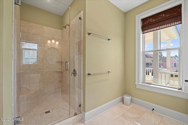 full bath featuring a stall shower, baseboards, and tile patterned floors