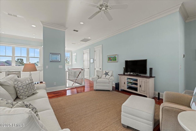 living room with baseboards, crown molding, visible vents, and wood finished floors