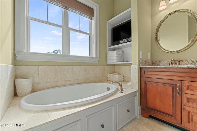 full bathroom with tile patterned flooring, a garden tub, and vanity