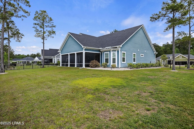 rear view of house with a sunroom, roof with shingles, a yard, and fence