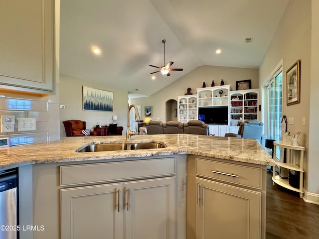 kitchen featuring a sink, light stone countertops, a ceiling fan, and lofted ceiling