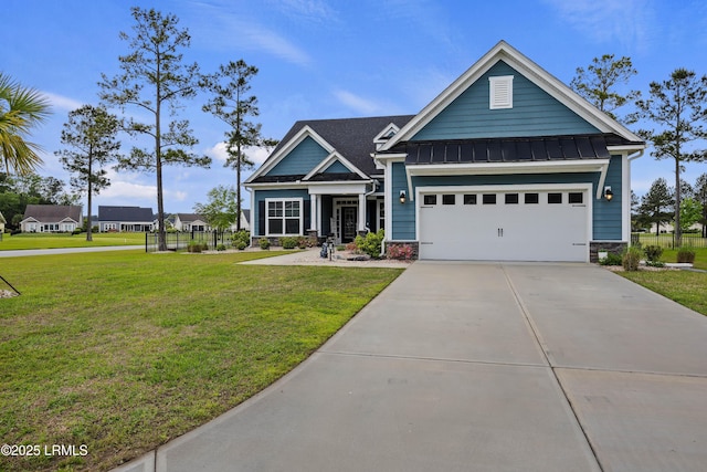 craftsman-style home featuring metal roof, a garage, concrete driveway, a front lawn, and a standing seam roof
