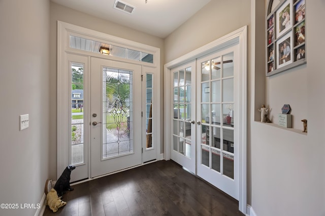 doorway with french doors, visible vents, and dark wood-style floors