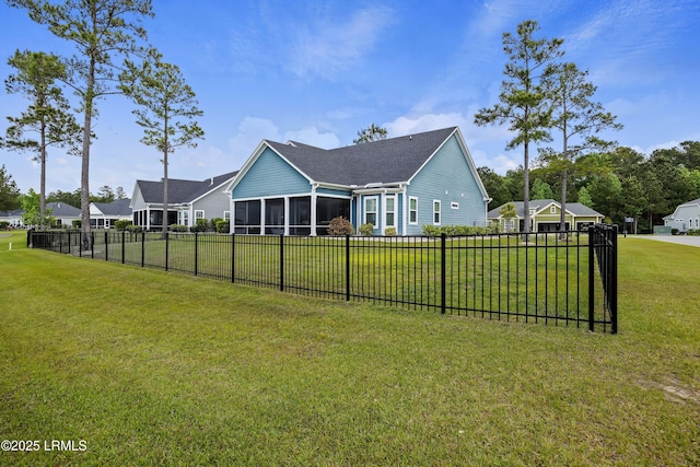rear view of property with a sunroom, a yard, and fence