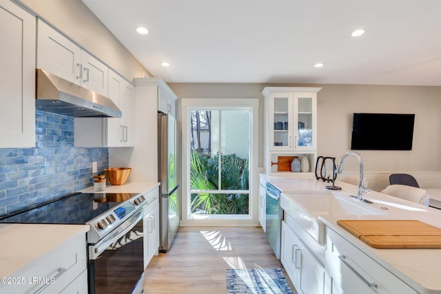 kitchen featuring stainless steel appliances, white cabinetry, sink, and tasteful backsplash