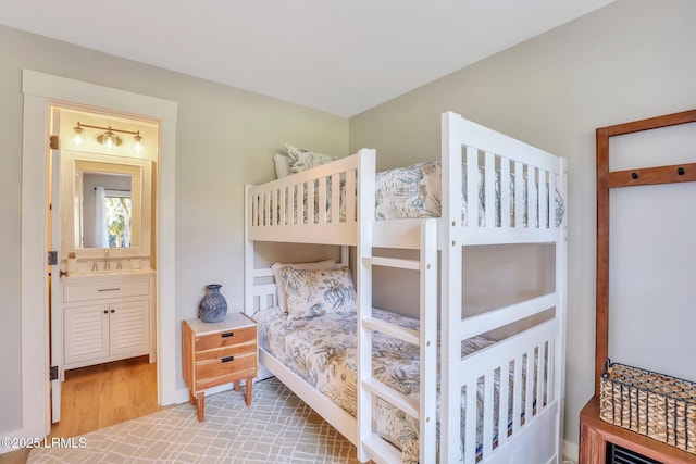 bedroom featuring sink and light hardwood / wood-style floors