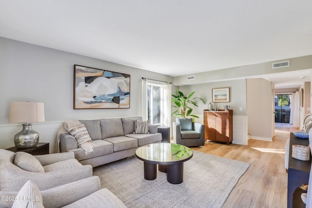 living room with a wealth of natural light and light hardwood / wood-style flooring