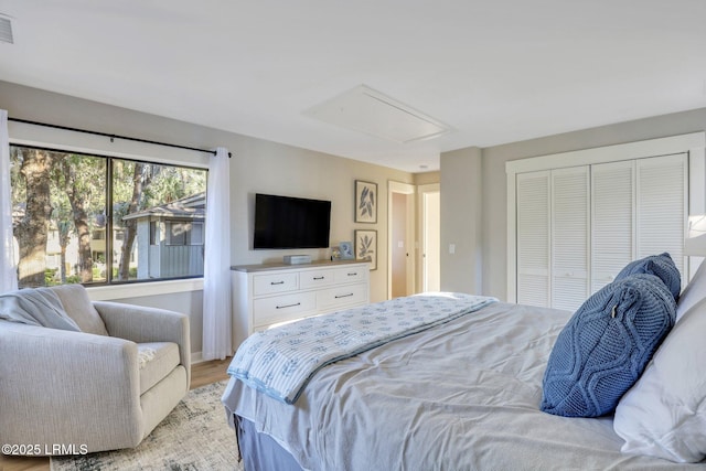 bedroom with light hardwood / wood-style floors and a closet