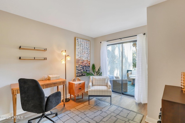 home office with light hardwood / wood-style flooring