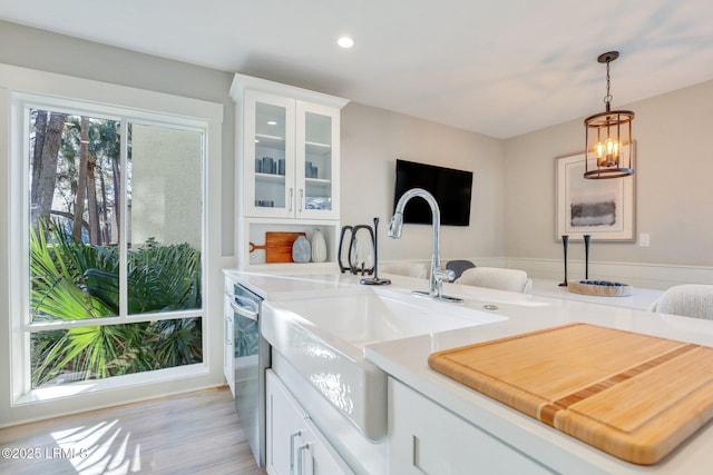 kitchen featuring sink, hanging light fixtures, and white cabinets